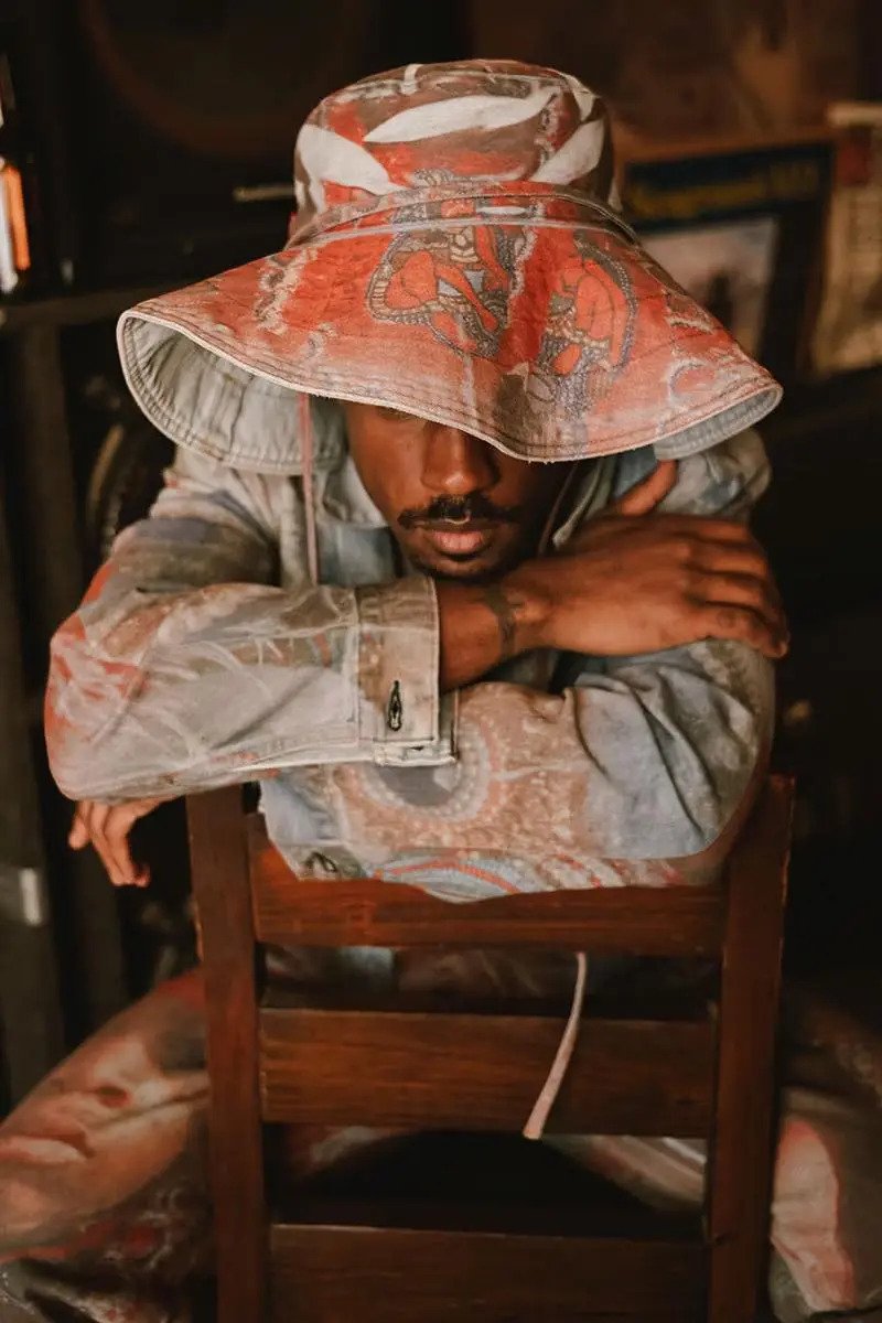 Denim Tears와 Levi's의 네 번째 협업 컬렉션 - Young Seminole Hunters와 Big Chief Demond Melancon에게 헌사를 보내며, 전통 의상을 입은 젊은 세미놀 헌터들의 사진이 프린트된 트러커 재킷과 진.